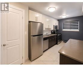 A kitchen with a refrigerator, microwave, and oven.