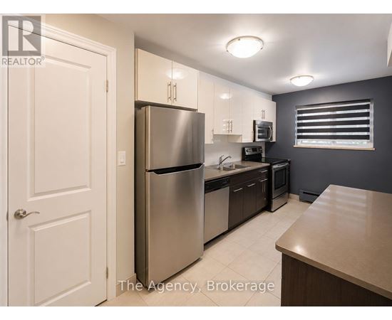 A kitchen with a refrigerator, microwave, and oven.
