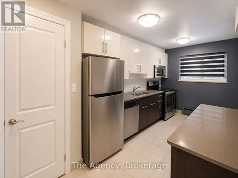 A kitchen with a refrigerator, microwave, and oven.