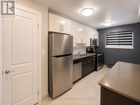 A kitchen with a refrigerator, microwave, and oven.