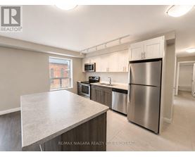 A kitchen with stainless steel appliances and a large island.
