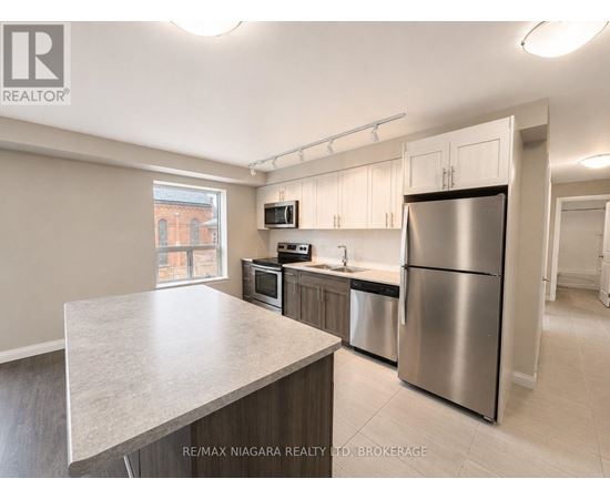 A kitchen with stainless steel appliances and a large island.