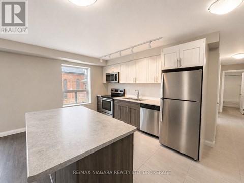A kitchen with stainless steel appliances and a large island.
