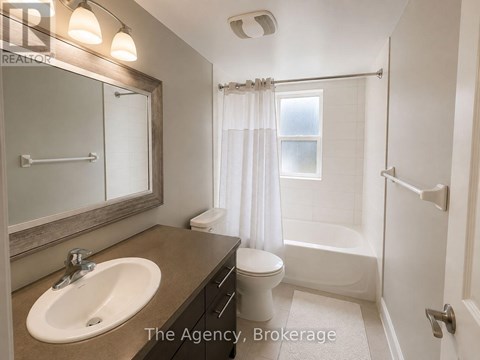 A bathroom with a sink, toilet, and bathtub.