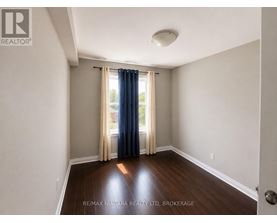 A room with a sliding glass door and a window with curtains.