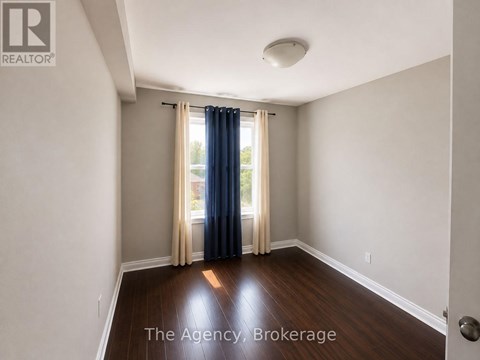 A room with a sliding glass door and a window with curtains.