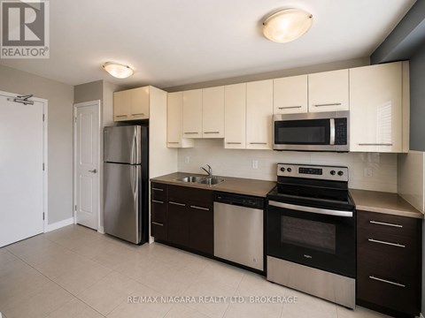A kitchen with white cabinets and stainless steel appliances.