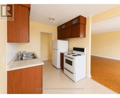 A kitchen with white appliances and wooden cabinets.
