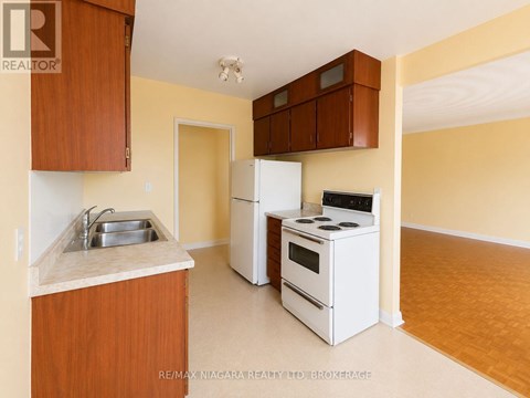A kitchen with white appliances and wooden cabinets.
