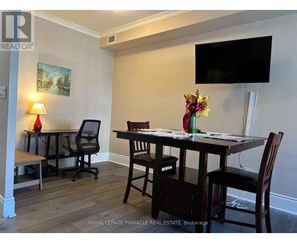 A dining room with a wooden table and chairs.