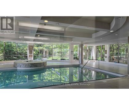 A large indoor swimming pool with a glass wall on one side.