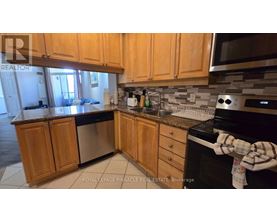 A kitchen with wooden cabinets and a black stove top oven.