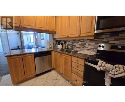 A kitchen with wooden cabinets and a black stove top oven.