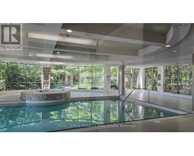 A large indoor swimming pool with a glass wall on one side.