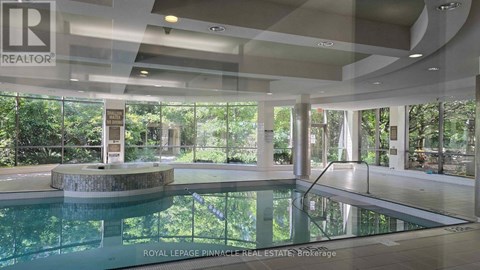 A large indoor swimming pool with a glass wall on one side.