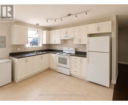A kitchen with white appliances and cabinets.