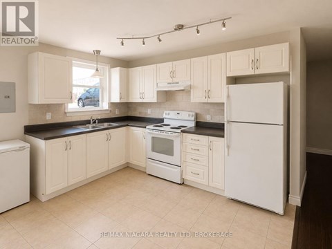 A kitchen with white appliances and cabinets.