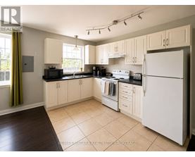 A kitchen with white appliances and wooden cabinets.
