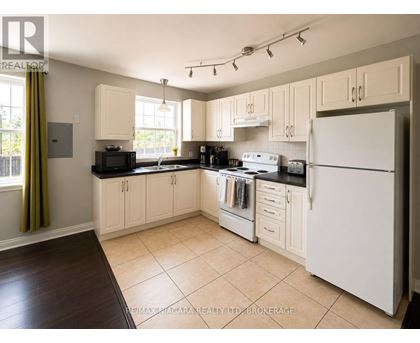 A kitchen with white appliances and wooden cabinets.