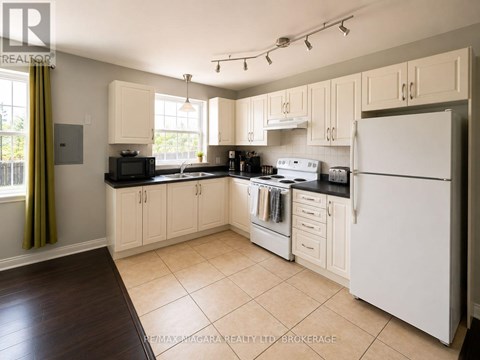 A kitchen with white appliances and wooden cabinets.