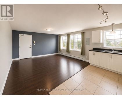 A spacious room with a door, windows, and a sink.