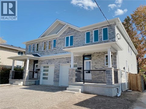 A two-story house with a white front porch and black railings.
