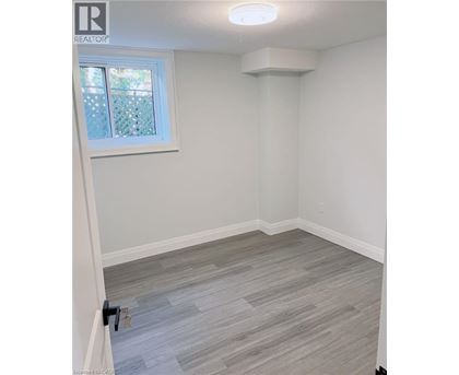 A room with a window and a grey floor.