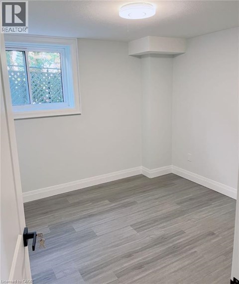 A room with a window and a grey floor.