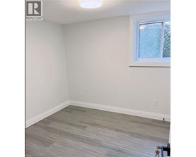 A room with a window and a wooden floor.