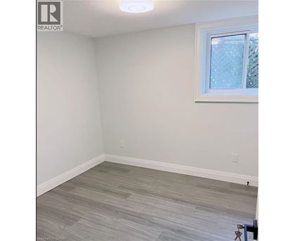 A room with a window and a wooden floor.