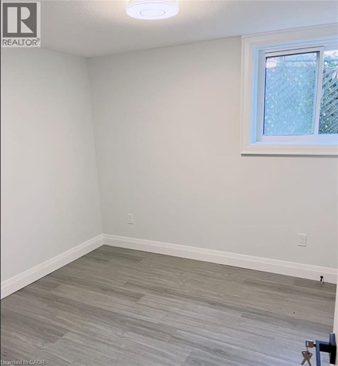 A room with a window and a wooden floor.
