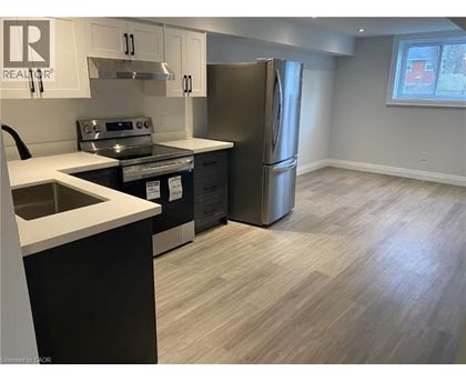 A kitchen with a stainless steel refrigerator, sink, and cabinets.