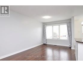 A room with a window and a wooden floor.