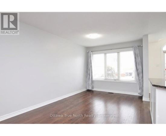 A room with a window and a wooden floor.