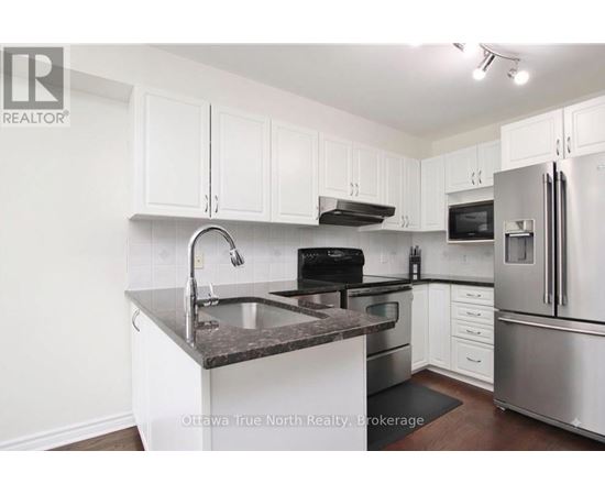 A kitchen with white cabinets and stainless steel appliances.