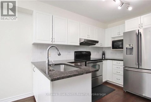 A kitchen with white cabinets and stainless steel appliances.