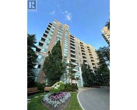 A tall residential building with a well-maintained garden in front.