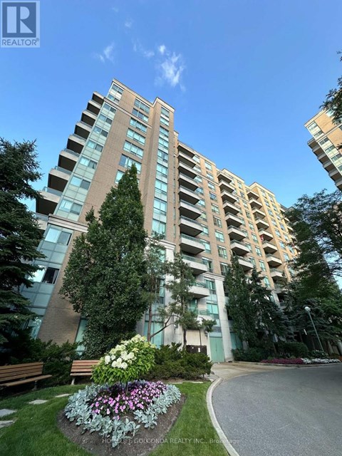 A tall residential building with a well-maintained garden in front.