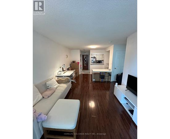 A living room with a white couch and a wooden floor.