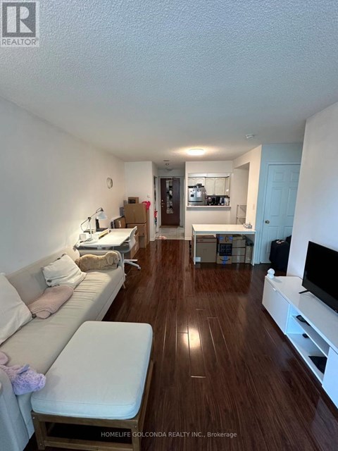 A living room with a white couch and a wooden floor.