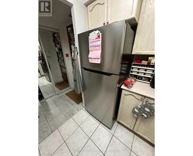 A refrigerator with a magnet on it in a kitchen.