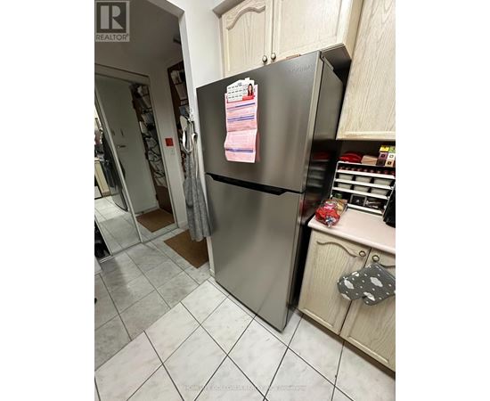 A refrigerator with a magnet on it in a kitchen.
