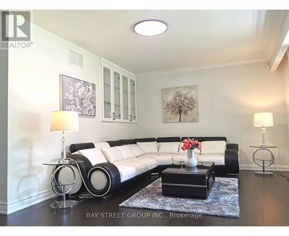 A living room with a white couch, a coffee table with flowers, and two lamps.