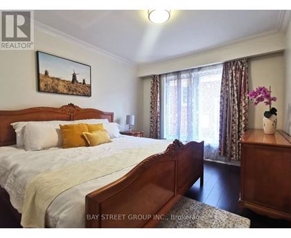 A bedroom with a large bed and a painting on the wall.