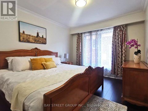 A bedroom with a large bed and a painting on the wall.