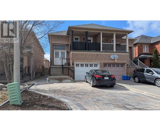 A black car is parked in front of a brick house with a garage.