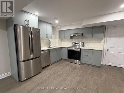 A kitchen with a refrigerator, stove, and cabinets.