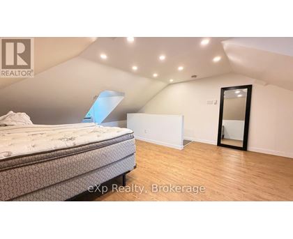 A bedroom with a bed, a mirror, and a dresser.