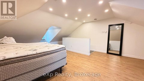 A bedroom with a bed, a mirror, and a dresser.