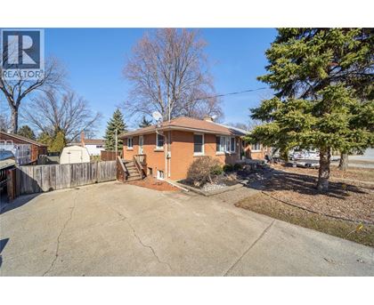 A house with a brown roof and a driveway in front of it.